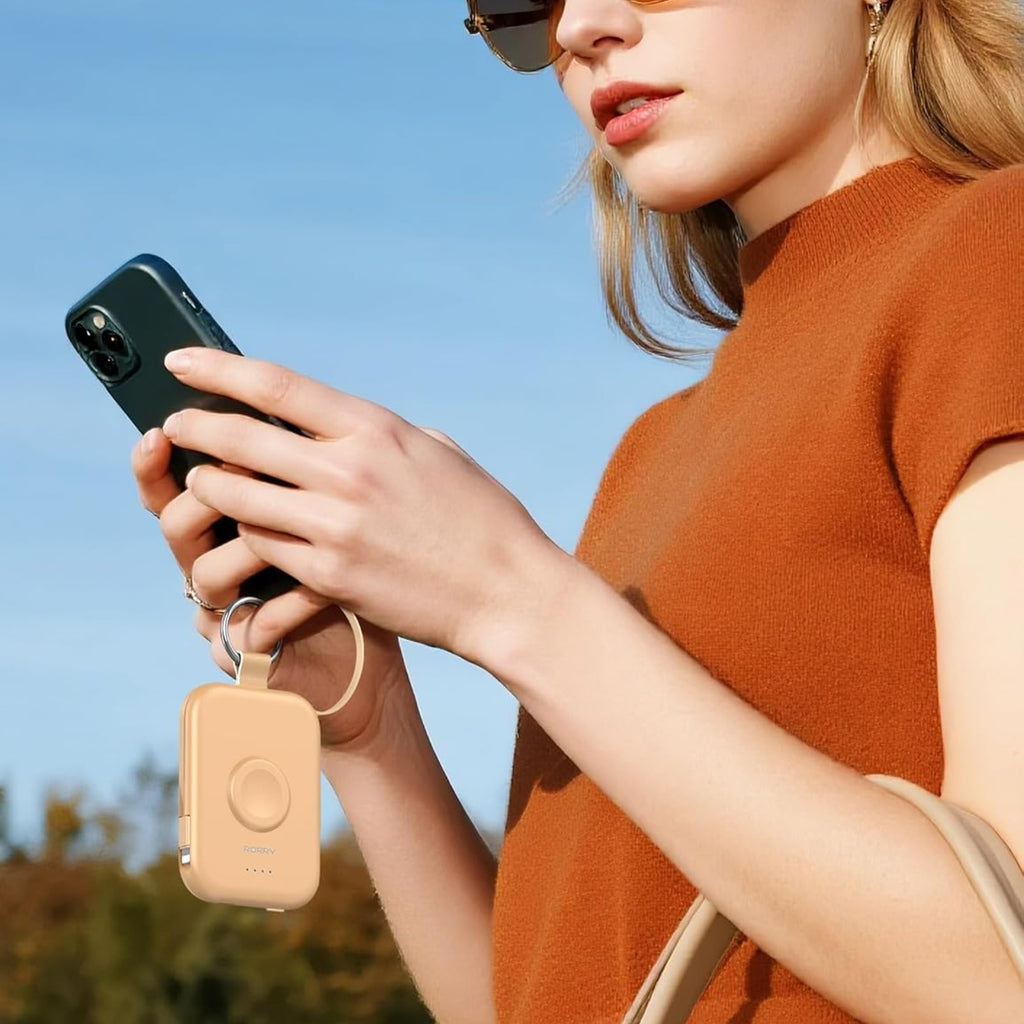 Woman using her phone with the RORRY CharmGo charger on her keys